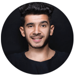 portrait d'un jeune homme souriant, brun avec une moustache, les oreilles décollées, un T-shirt noir à col rond