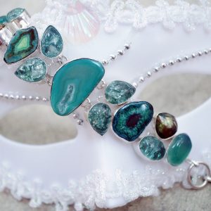 bracelet fantaisie pierres turquoises asymétriques sur un masque blanc de Venise, bijou, issu de la collection Fantaisie de La Vie en Or