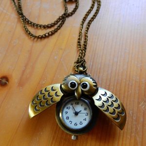 bijou, collier en or, avec un pendentif en forme de hibou avec les ailes déployées qui laissent découvrir une petite montre